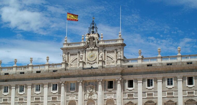 Detail of the façade of the Royal Palace in Madrid with the Spanish flag. King Felipe VI