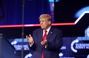 Former US President Donald Trump applauds as he stands during his meeting with attendees at the People's Convention at Huntington Place in Detroit, Michigan, in June 2024