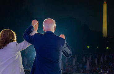 US President Joe Biden, in a navy blue suit, and Vice President Kamala Harris, in a beige suit, in front of a crowd of people during the 4th of July celebration at the White House