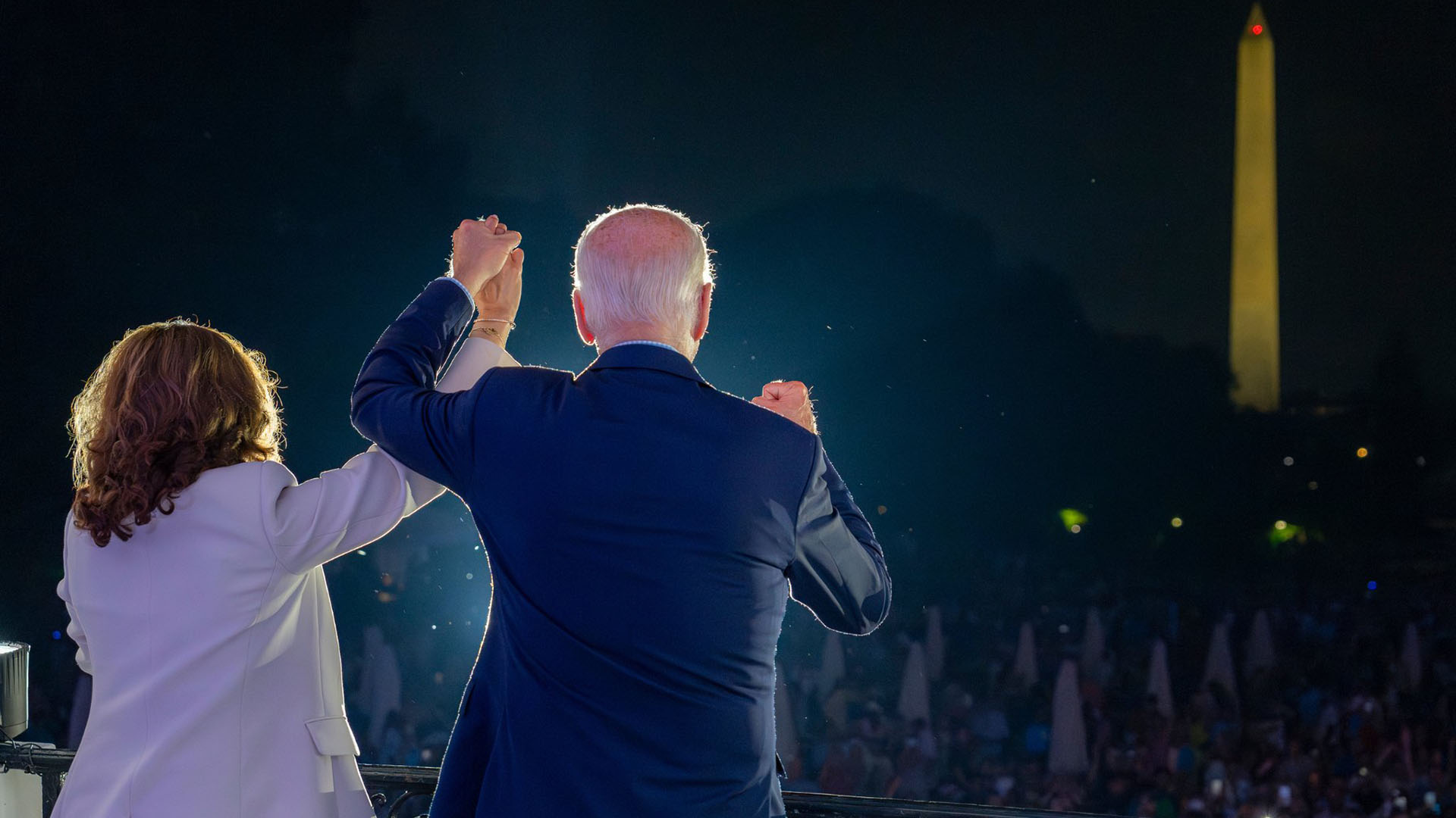 El presidente de Estados Unidos, Joe Biden, con un traje azul marino, y la vicepresidenta Kamala Harris, con un traje beige, frente a una multitud de personas durante la celebración del 4 de julio en la Casa Blanca