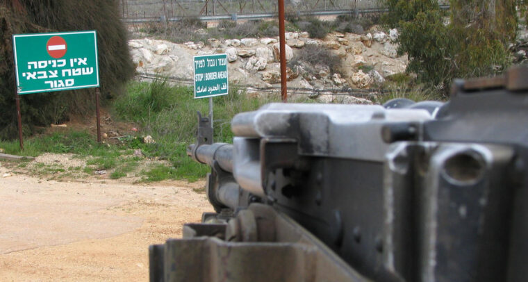 Frontera de Israel y Líbano. Foto tomada desde un carromato militar. En la carretera, unos carteles en verde con letras blancas (y la señal de stop) en hebreo que dicen “Prohibida la entrada, zona militar cerrada”, y en inglés “Alto, frontera adelante”