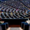 Vista del hemiciclo del Parlamento Europeo con los parlamentarios sentados en sesión. La foto fue tomada desde la puerta en lo alto de una escalera pequeña en una cabina lateral con cristales.