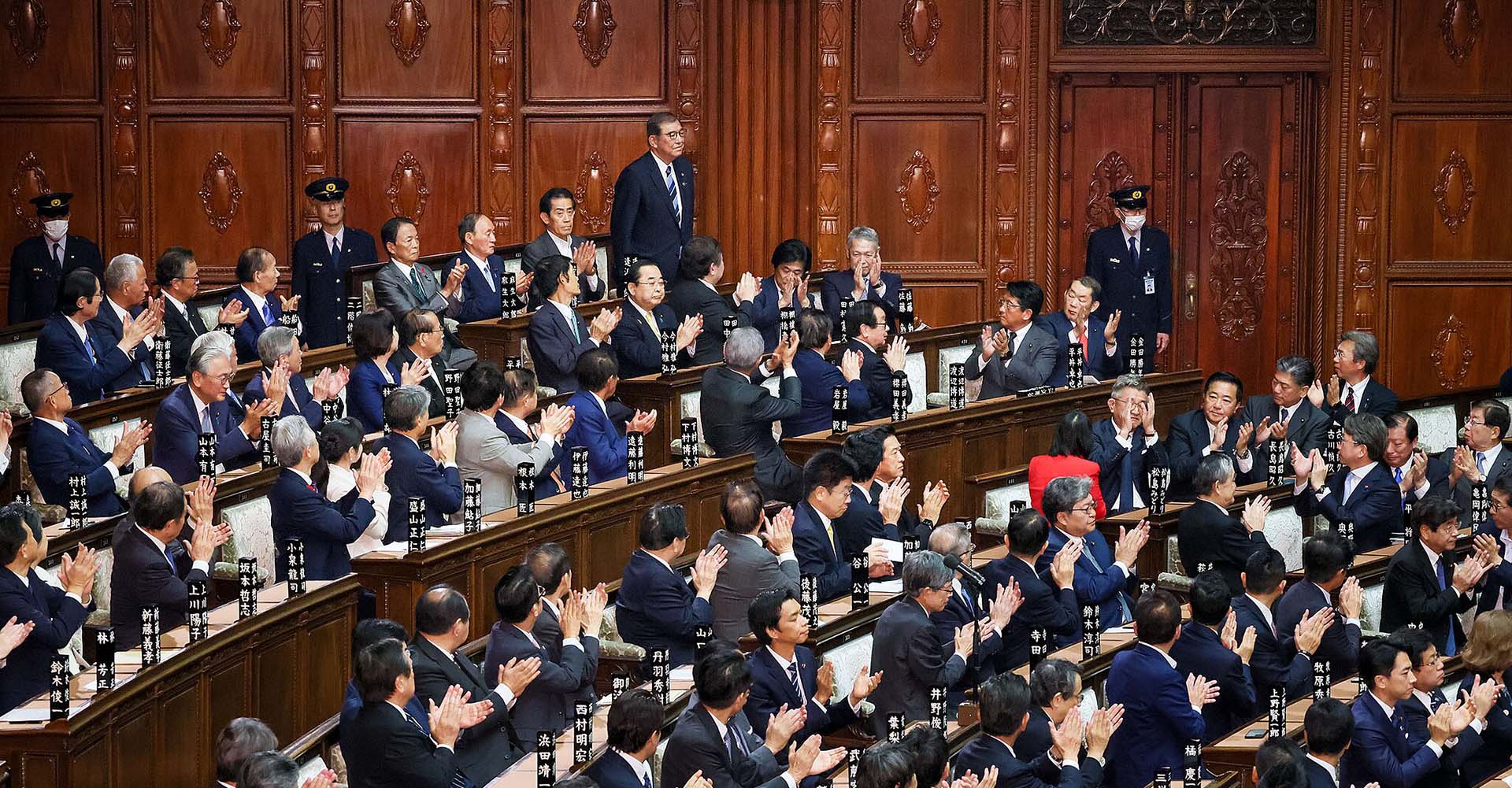 Shigeru Ishiba (de pie y al fondo) recibe los aplausos del resto de miembros (sentados) tras la votación en la Cámara de Representantes y la Cámara de Consejeros de su nominación como primer ministro de Japón.