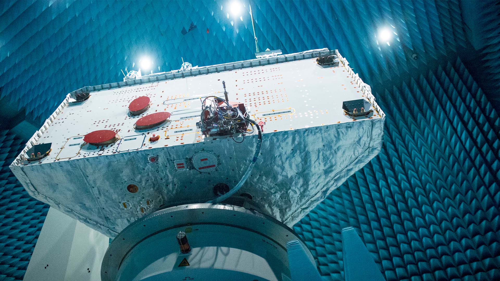 El orbitador BepiColombo de la European Space Agency inclinado durante pruebas de compatibilidad electromagnética en la cámara Maxwell, con paredes recubiertas de espuma anecoica para simular el espacio y evaluar su comunicación con la Tierra. tecnologías duales