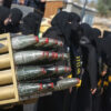 Grupo de mujeres vestidas de negro, con el rostro cubierto, asisten a un campamento militar de verano para jóvenes, organizado por las Brigadas Al-Quds, el ala militar del Movimiento de la Yihad Islámica, dentro de uno de sus emplazamientos militares en la ciudad de Khan Yunis. En primer plano, se aprecian unos proyectiles