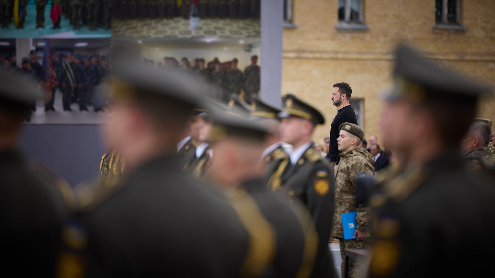 Acto del Día de los Defensores de Ucrania, el 1 de octubre de 2024. En primer plano difuminado, soldados y oficiales ucranianos están formados durante el evento. De fondo, el presidente de Ucrania, Volodímir Zelenski, participando en la ceremonia de homenaje. Ucrania ante sus límites