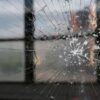 Image: A closeup shot of a cracked window during sunset with windows in the background. Elcano Forum on Global Terrorism