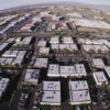 Vista área diurna de edificios de oficinas de empresas tecnológicas en Silicon Valley, California, rodeados de naturaleza y cielo despejado. elecciones de Estados Unidos