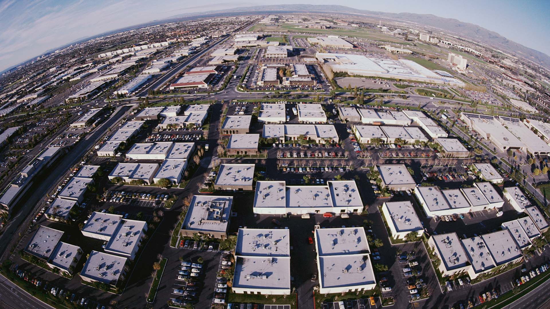 Vista área diurna de edificios de oficinas de empresas tecnológicas en Silicon Valley, California, rodeados de naturaleza y cielo despejado. elecciones de Estados Unidos