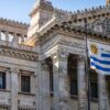 Fachada del Palacio Legislativo de Montevideo, un edificio de estilo neoclásico ubicado en Montevideo, Uruguay, que alberga el Parlamento del país. La imagen muestra una vista frontal del edificio, con una bandera del propio país ondeando delante. Elecciones en Uruguay