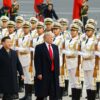 Primer plano de Donald Trump (a la derecha) camina junto a Xi Jinping (izquierda) sobre una alfombra roja en un evento en Pekín, China. En el fondo, una fila de guardias de honor chinos detrás de ellos, sosteniendo rifles. Victoria de trump