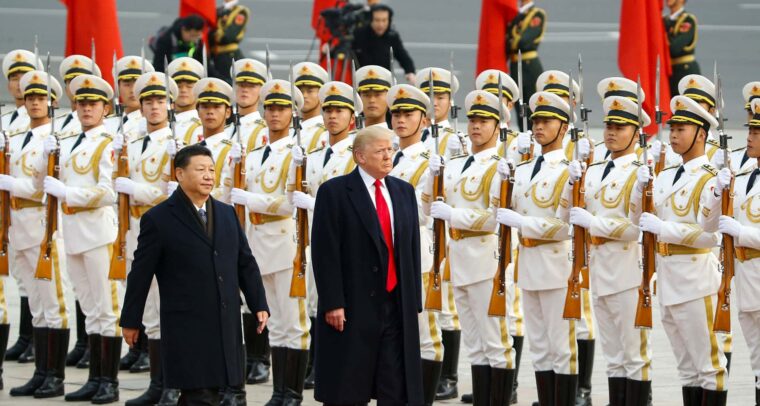 Primer plano de Donald Trump (a la derecha) camina junto a Xi Jinping (izquierda) sobre una alfombra roja en un evento en Pekín, China. En el fondo, una fila de guardias de honor chinos detrás de ellos, sosteniendo rifles. Victoria de trump