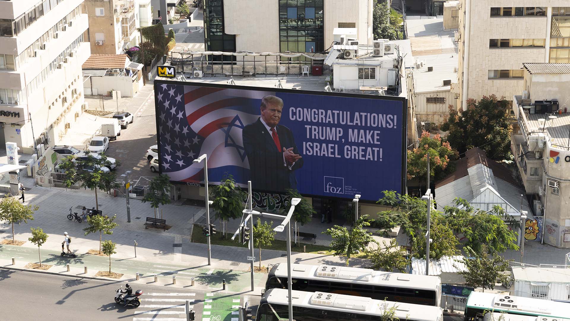 Valla publicitaria en Tel Aviv (Israel) muestra el mensaje de felicitación ’Congratulations! Trump, make Israel great!’ (‘’¡Felicidades! Trump, ¡haz grande a Israel!’’) dirigido a Donald Trump, mientras vehículos transitan por la calle en una escena urbana dinámica. Oriente Medio