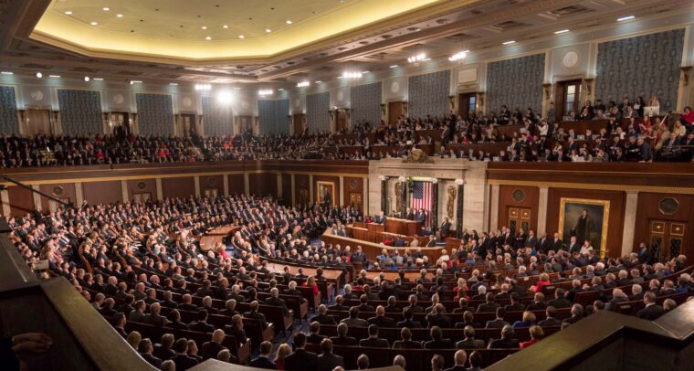 View of the floor of the US Congress during the 2018 State of the Union address, with the president at the podium facing lawmakers. Donald Trump