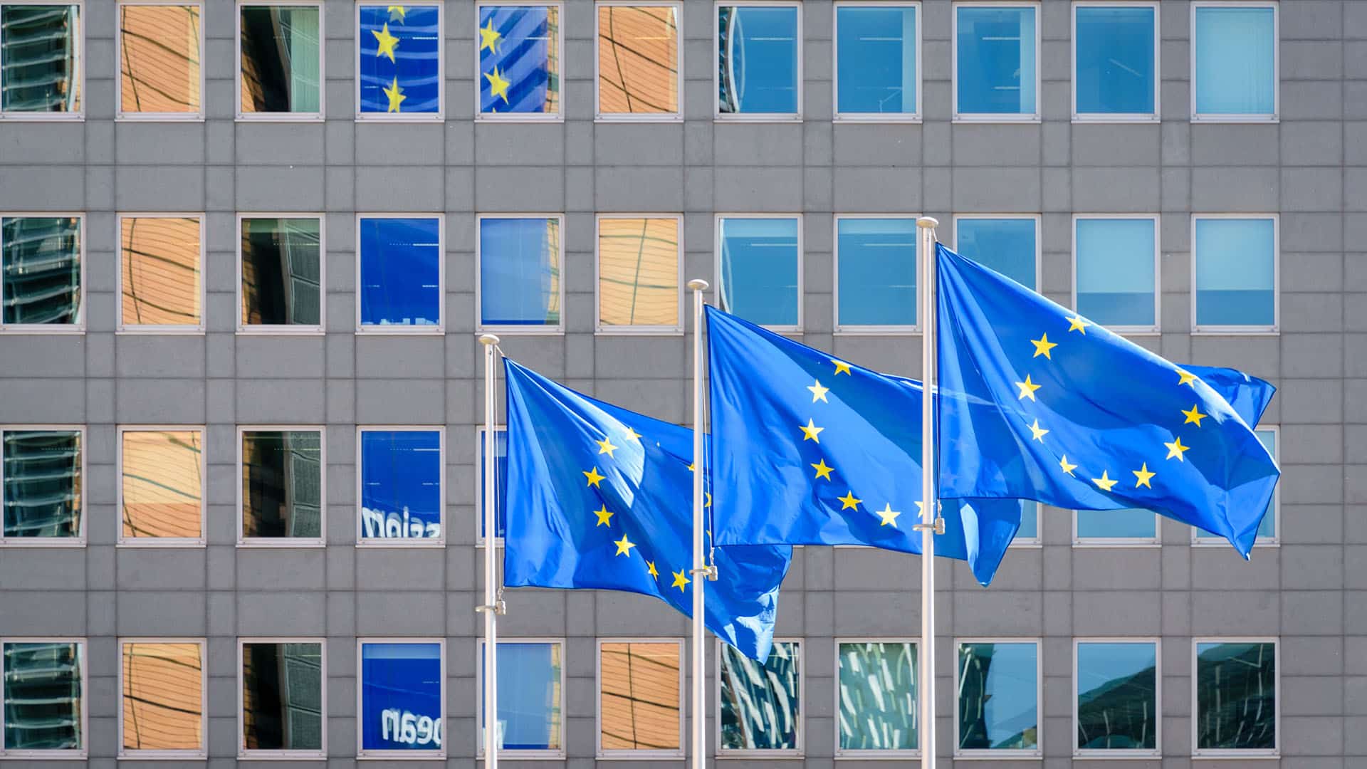 Tres banderas de la Union Europea (UE) ondean al viento a toda asta frente a las ventanas del edificio Berlaymont, sede de la Comisión Europea (el ejecutivo de la UE) en Bruselas, Bélgica