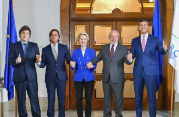 De izquierda a derecha: Javier Milei, Luis Alberto Lacalle Pou, Ursula von der Leyen, Luiz Inácio Lula da Silva, and Santiago Peña en Montevideo (Uruguay), tras alcanzar un acuerdo en las negociaciones para el Acuerdo UE-Mercosur en 2024. Al fondo, se aprecian las banderas de la Unión Europea y Mercosur. Acuerdo UE-Mercosur