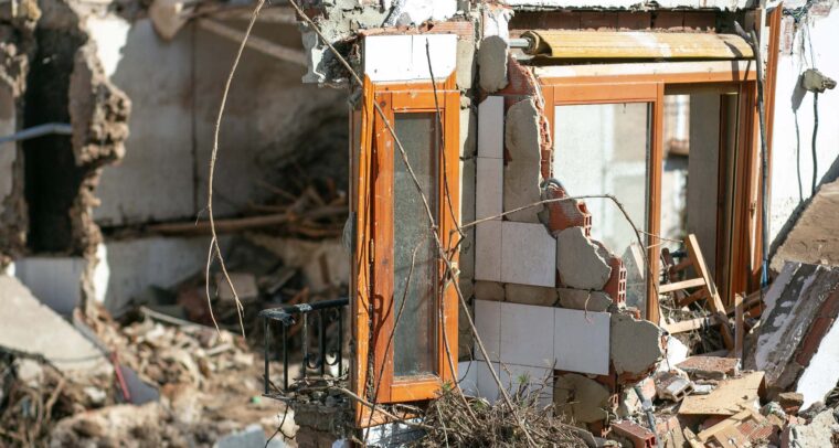 Partially collapsed building in Letur (Albacete) with shattered walls, exposed bricks, broken windows, and debris scattered around, showing damage caused by the ‘DANA’ storm. water