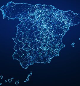 Mapa de España digitalizado con una red de conexiones iluminadas en azul claro, con un fondo en un gradiente de color entre azul marino y negro. España