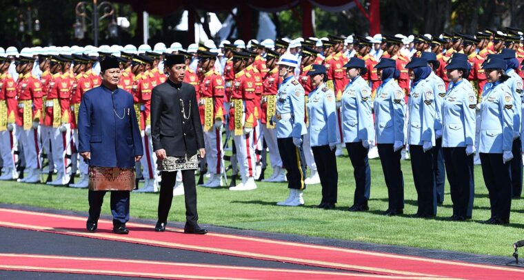 Prabowo Subianto, presidente de Indonesia, y Joko Widodo, expresidente, durante la ceremonia de despedida en el Palacio Merdeka, rodeados de la guardia de honor. Subianto