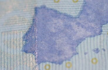 Detalle de un billete de 20 euros de una parte del mapa de Europa (la península Ibérica y parte de Francia), donde ser aprecia la textura del papel, el brillo parcial de la tinta, las líneas azules finas y pequeños círculos dorados