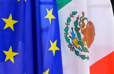 Banderas de la Unión Europea (azul con estrellas amarillas en círculo) y de México (tricolor con franjas verde, blanca y roja, con un escudo formado por un águila y una serpiente) en la XXV Reunión de la Comisión Parlamentaria Mixta México-Unión Europea de 2018. México