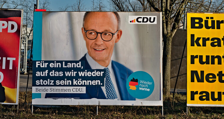 Vallas con propaganda de las recientes elecciones en Alemania en una calle de Frankfurt (Alemania). Al centro, el cartel del partido CDU con la imagen de Friedrich Merz y un texto en alemán que dice “Por un país del que podamos volver a sentirnos orgullosos. Ambos votos para CDU”. Foto: conceptphoto.info (CC BY 2.0)