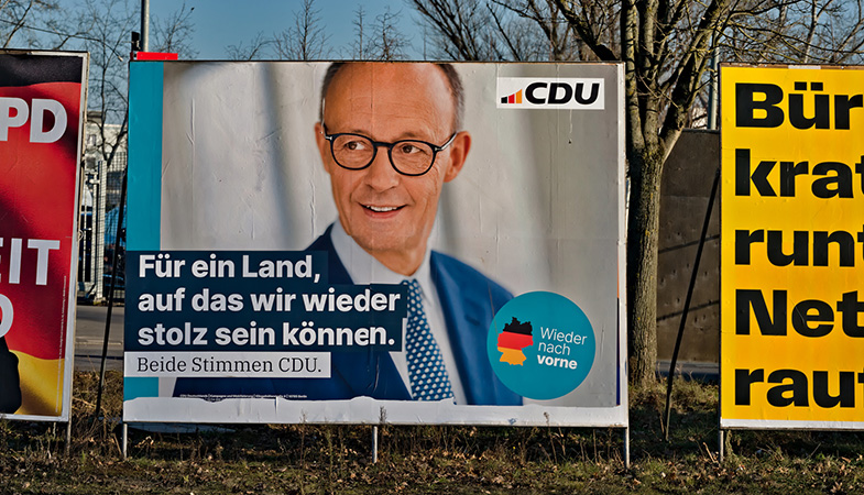 Vallas con propaganda de las recientes elecciones en Alemania en una calle de Frankfurt (Alemania). Al centro, el cartel del partido CDU con la imagen de Friedrich Merz y un texto en alemán que dice “Por un país del que podamos volver a sentirnos orgullosos. Ambos votos para CDU”. Foto: conceptphoto.info (CC BY 2.0)