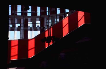 Juego de luces y sombras en los ventanales de la cúpula y una escalera roja de la estación de trenes de Cercanías de Atocha, Madrid (España), lugar de los atentados del 11-M en 2004