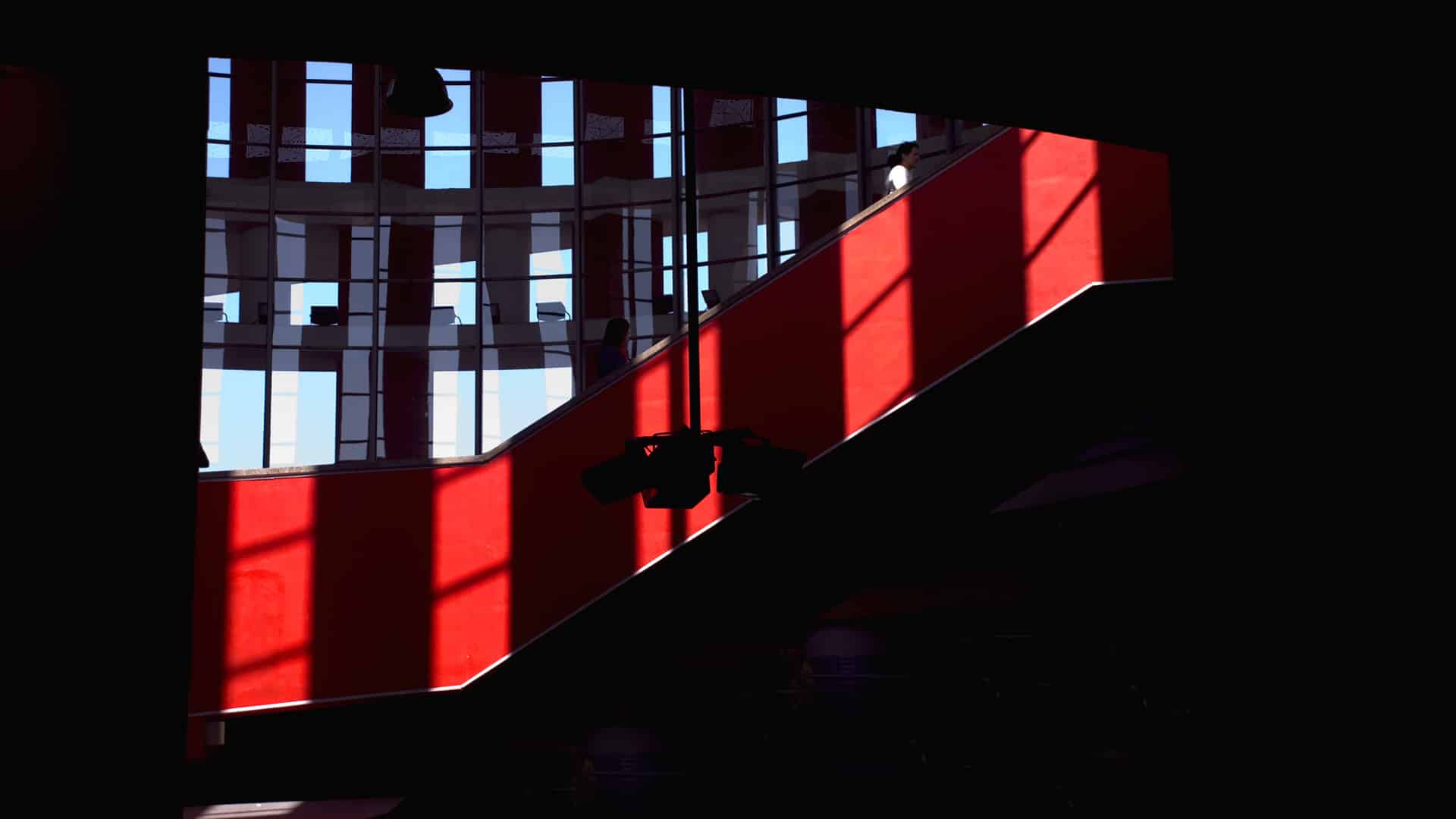 Juego de luces y sombras en los ventanales de la cúpula y una escalera roja de la estación de trenes de Cercanías de Atocha, Madrid (España), lugar de los atentados del 11-M en 2004