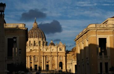 Fachada de la Basílica de San Pedro iluminada por la luz dorada del atardecer en la Ciudad del Vaticano. Cónclave