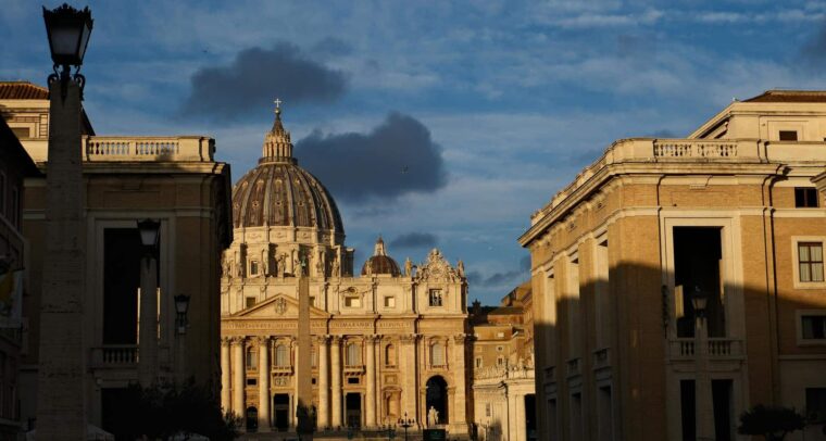 Fachada de la Basílica de San Pedro iluminada por la luz dorada del atardecer en la Ciudad del Vaticano. Cónclave