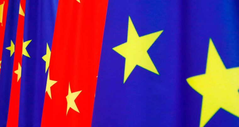 A row of European Union flags (blue with yellow stars) and Chinese flags (red with yellow stars) waving side by side during the 2020 EU–China summit. China