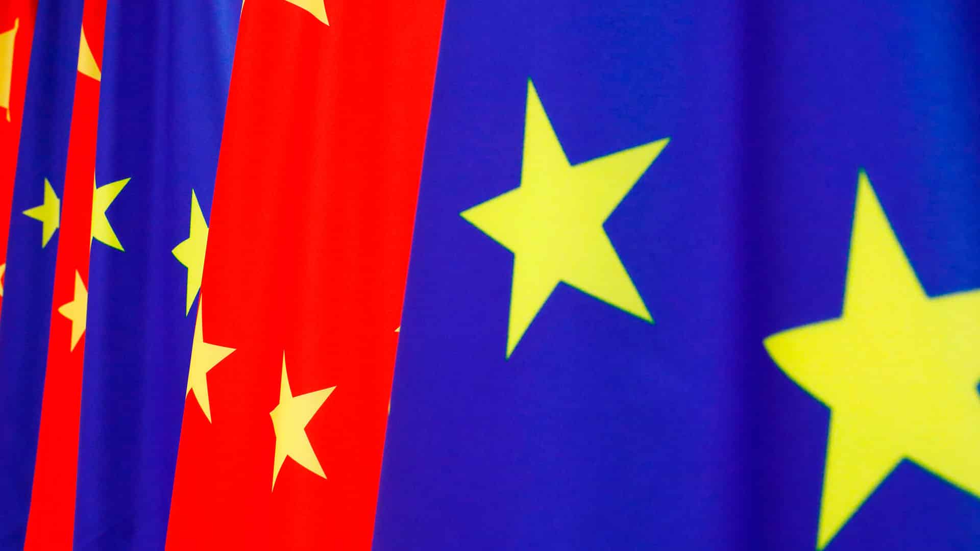 Sucesión de banderas de la Unión Europea (azul con estrellas amarillas) y de China (roja con estrellas amarillas) ondeando juntas en la cumbre UE-China de 2020. China