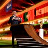 El presidente de la FIFA, Gianni Infantino, de pie sobre una tarima y vestido con traje oscuro y camisa blanca, sostiene una tarjeta negra con el texto “FIFA World Cup 2030” junto a los nombres y banderas de Marruecos, España y Portugal, anunciando oficialmente su designación como países anfitriones. A su derecha, el trofeo de la Copa Mundial se exhibe en un pedestal acristalado, destacado por una iluminación cenital. Al fondo, una pantalla LED proyecta los mismos elementos gráficos. Mundial 2030