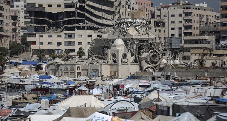 Palestinos desplazados hacinados en tiendas improvisadas levantadas a lo largo de la costa en el puerto de Gaza, donde soportan duras condiciones en tiendas improvisadas levantadas a lo largo de la costa (24/05/2025). Tras la distribución aérea de panfletos por parte del ejército israelí advirtiendo de ataques inminentes, especialmente en el norte de Gaza y otras zonas, los palestinos desplazados han buscado refugio en el puerto. Foto: Ali Jadallah/Anadolu vía Getty Images.