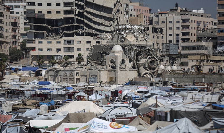 Palestinos desplazados hacinados en tiendas improvisadas levantadas a lo largo de la costa en el puerto de Gaza, donde soportan duras condiciones en tiendas improvisadas levantadas a lo largo de la costa (24/05/2025). Tras la distribución aérea de panfletos por parte del ejército israelí advirtiendo de ataques inminentes, especialmente en el norte de Gaza y otras zonas, los palestinos desplazados han buscado refugio en el puerto. Foto: Ali Jadallah/Anadolu vía Getty Images.