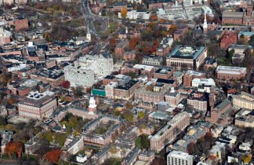 Vista aérea del campus principal de la Universidad de Harvard en Cambridge (Massachusetts), en la que se ve la distribución de las calles, donde priman edificios de ladrillo y árboles con follaje otoñal. Universidades