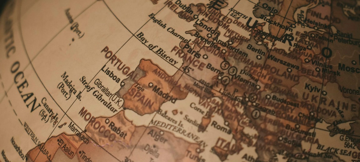 Primer plano de un globo terráqueo clásico, centrado en Europa y las regiones circundantes, con nombres de ciudades y países visibles. Unión Europea