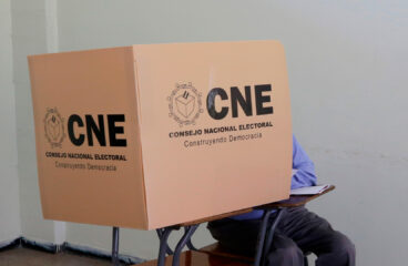 Un ciudadano hondureño (sentado, con pantalones grises y camisa azul) emite su voto en un centro electoral de Tegucigalpa durante las elecciones primarias, dentro de una cabina del Consejo Nacional Electoral (CNE), 9 de marzo de 2025. electoral