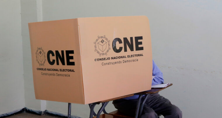 Un ciudadano hondureño (sentado, con pantalones grises y camisa azul) emite su voto en un centro electoral de Tegucigalpa durante las elecciones primarias, dentro de una cabina del Consejo Nacional Electoral (CNE), 9 de marzo de 2025. electoral