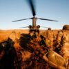 Soldados del Ejército de Tierra español corren hacia un helicóptero con las hélices en movimiento, durante un ejercicio militar en el campo. Defensa