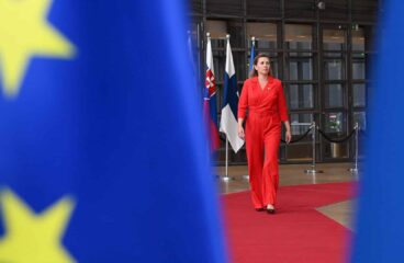 La primera ministra de Dinamarca, Mette Frederiksen, camina sobre la alfombra roja durante la cumbre del Consejo Europeo el 17 de octubre de 2024 en Bruselas, enmarcada por banderas de la UE. UE