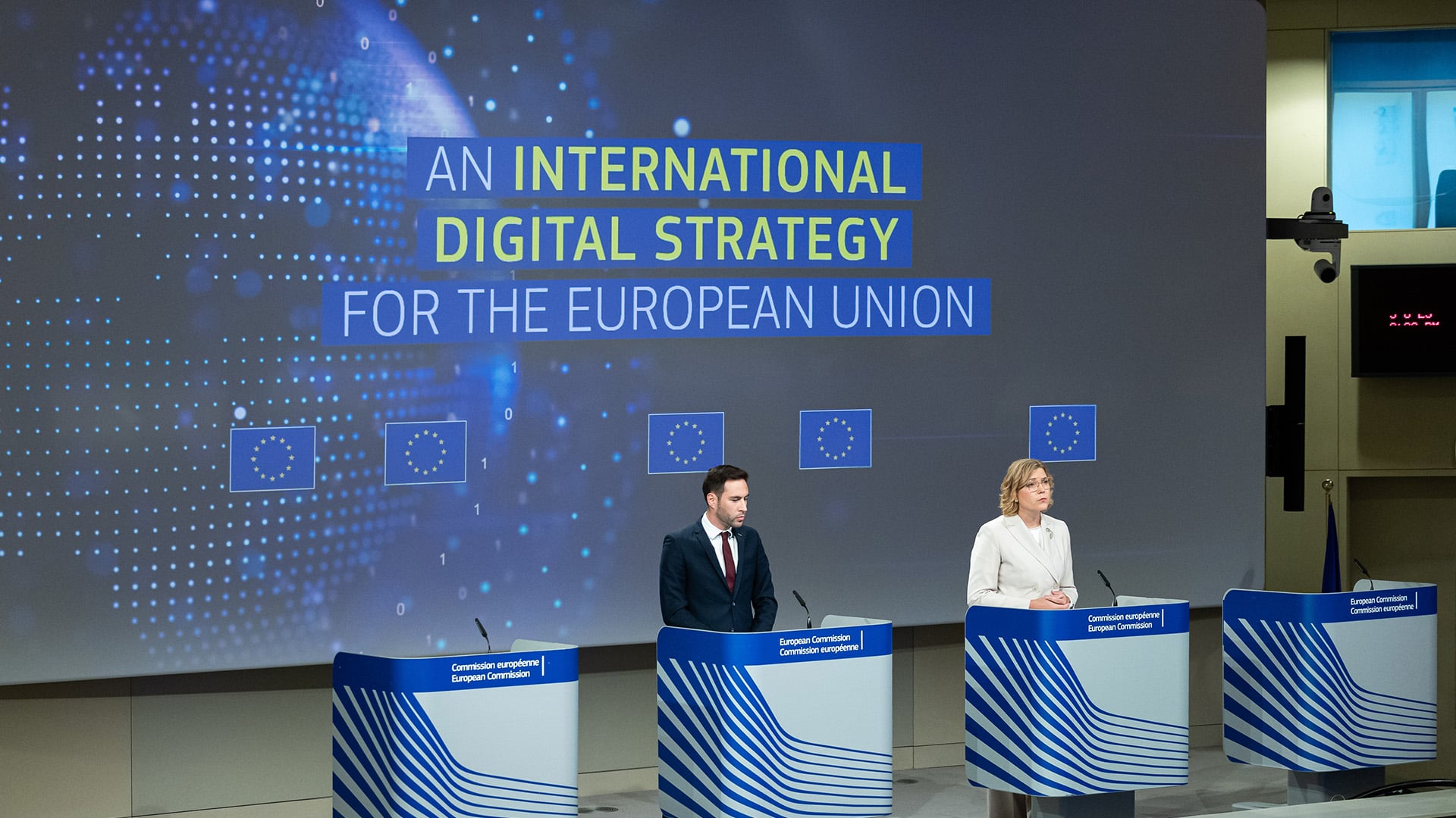 Rueda de prensa de la Comisión Europea el 5 de junio de 2025 sobre la Estrategia Digital Internacional de la UE. Henna Virkkunen, vicepresidenta ejecutiva de Soberanía Tecnológica, y Guillaume Mercier, portavoz de Ampliación y Asociaciones Internacionales, están de pie tras atriles. Al fondo, una pantalla proyecta el título “An International Digital Strategy for the European Union” sobre un gráfico digital del planeta y cinco pequeñas banderas de la UE. Estrategia Digital