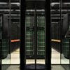 Vista del superordenador MareNostrum 4 en el Barcelona Supercomputing Center, con filas de servidores iluminados en una sala de alta seguridad. IA
