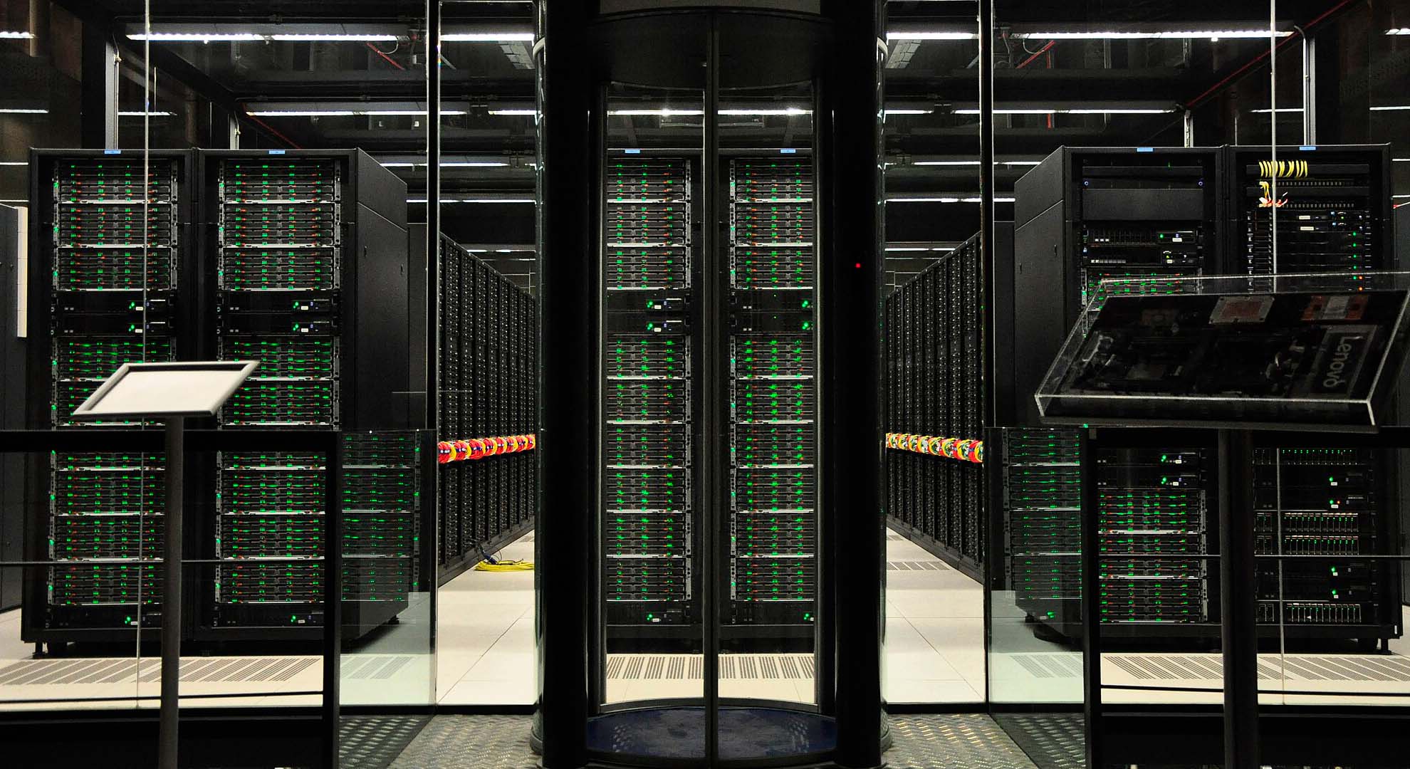 Vista del superordenador MareNostrum 4 en el Barcelona Supercomputing Center, con filas de servidores iluminados en una sala de alta seguridad. IA