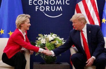 Ursula von der Leyen (presidenta de la Comisión Europea) y Donald Trump (presidente de EEUU) estrechan manos en el Foro Económico Mundial de Davos 2020 durante una reunión bilateral entre la Unión Europea y Estados Unidos, con banderas de ambos bloques al fondo. Acuerdo comercial