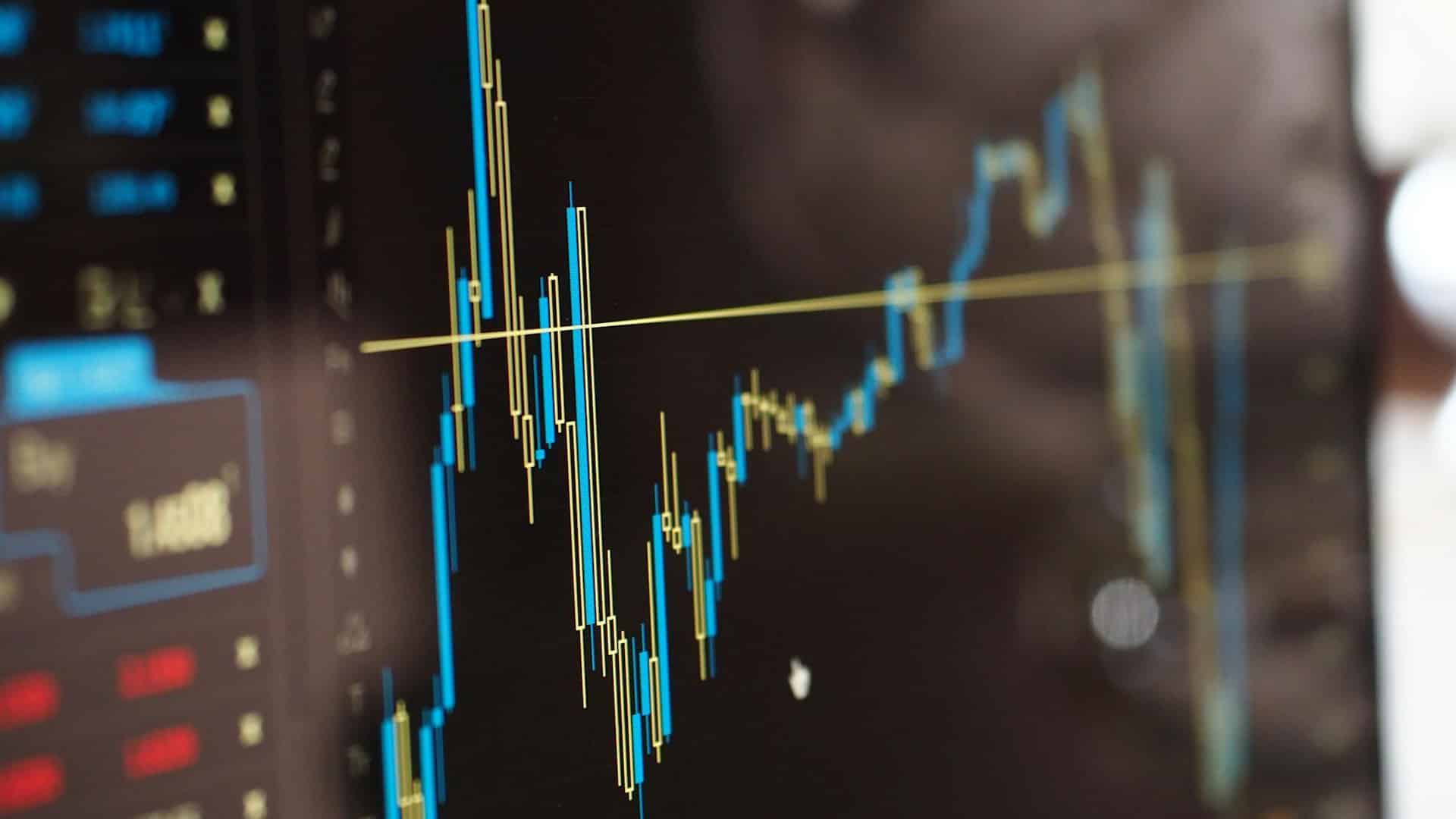 Primer plano de un monitor con gráficos financieros en azul y amarillo. Impuestos