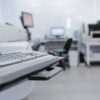 Infraestructura tecnológica en un laboratorio clínico, con estaciones de trabajo y equipamiento avanzado para el análisis de datos. Salud