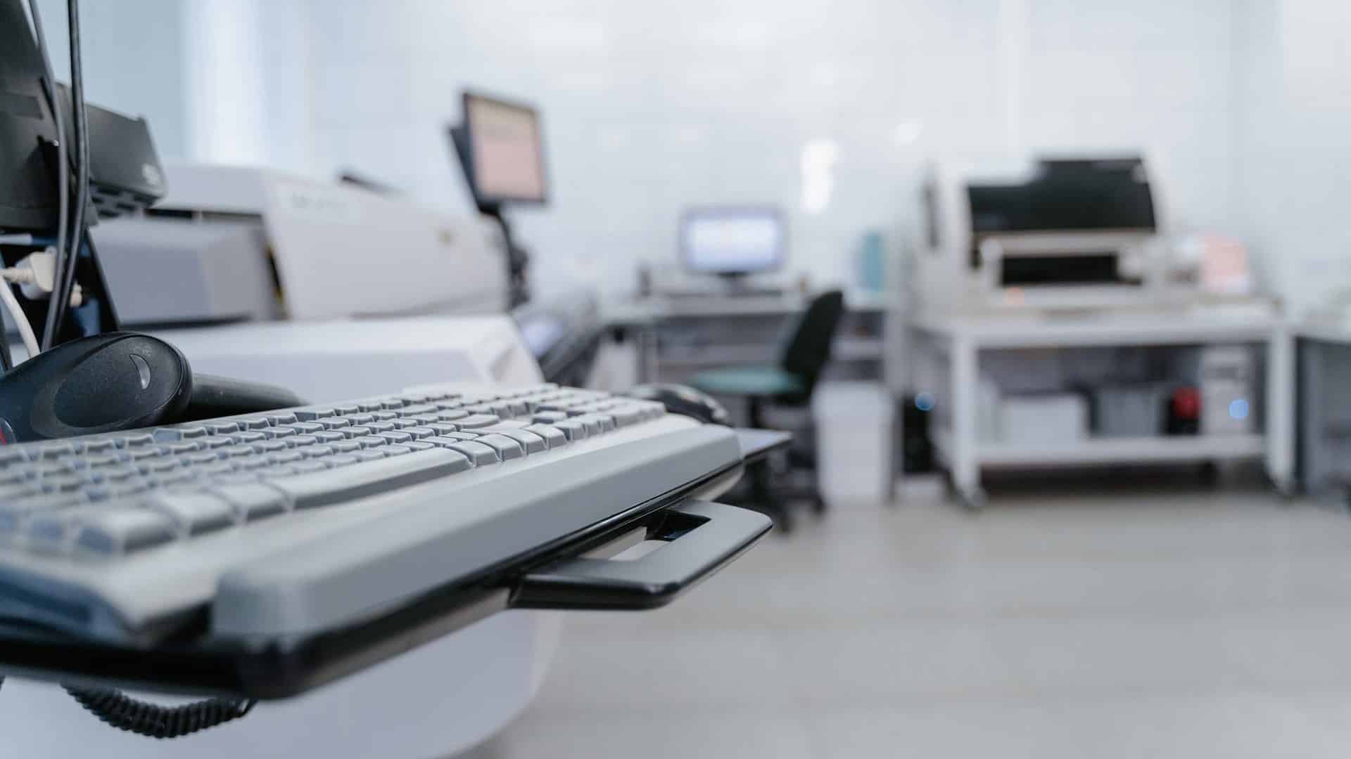Infraestructura tecnológica en un laboratorio clínico, con estaciones de trabajo y equipamiento avanzado para el análisis de datos. Salud