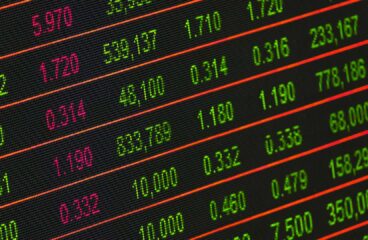 Pantalla electrónica con cotizaciones bursátiles en tiempo real, mostrando precios de acciones, variaciones y volúmenes de negociación. Dólar